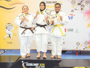 Nur Ain Hafiezza binti Amran(dua dari kiri) menyumbang pingat emas kepada kontijen Terengganu Hanelang setelah berentap dalam kategori wanita melebihi 70kg akhir. Judoka Sabah; Mel Motusin(kiri) turut berkongsi pingat emas manakala judoka tuan rumah; Aida Adriana meraih gangsa di hari pertama kejohanan judo Sukan Malaysia(SUKMA) Perak 2018 yang telah berlansung di Dewan SMJK Krian, Kerian. Kredit Foto - Sekretariat SUKMA Perak 2018