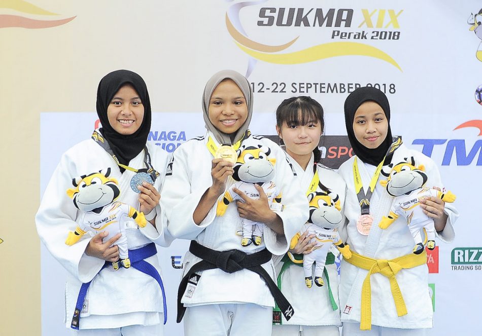 Alyaa Yasmeen binti Rosali(dua dari kiri) menyumbang pingat emas kepada kontijen Terengganu Hanelang setelah berentap dalam kategori wanita bawah 44kg akhir. Judoka tuan rumah; Nor Aina Faqihah binti Norfizal Hafizie(kiri) meraih pingat perak manakala judoka Selangor; Chew Xue Er dan judoka Johor Nurul Ain binti Saiful Airy berkongsi gangsa di hari kedua kejohanan judo Sukan Malaysia(SUKMA) Perak 2018 yang telah berlansung di Dewan SMJK Krian, Kerian. Kredit Foto - Sekretariat SUKMA Perak 2018